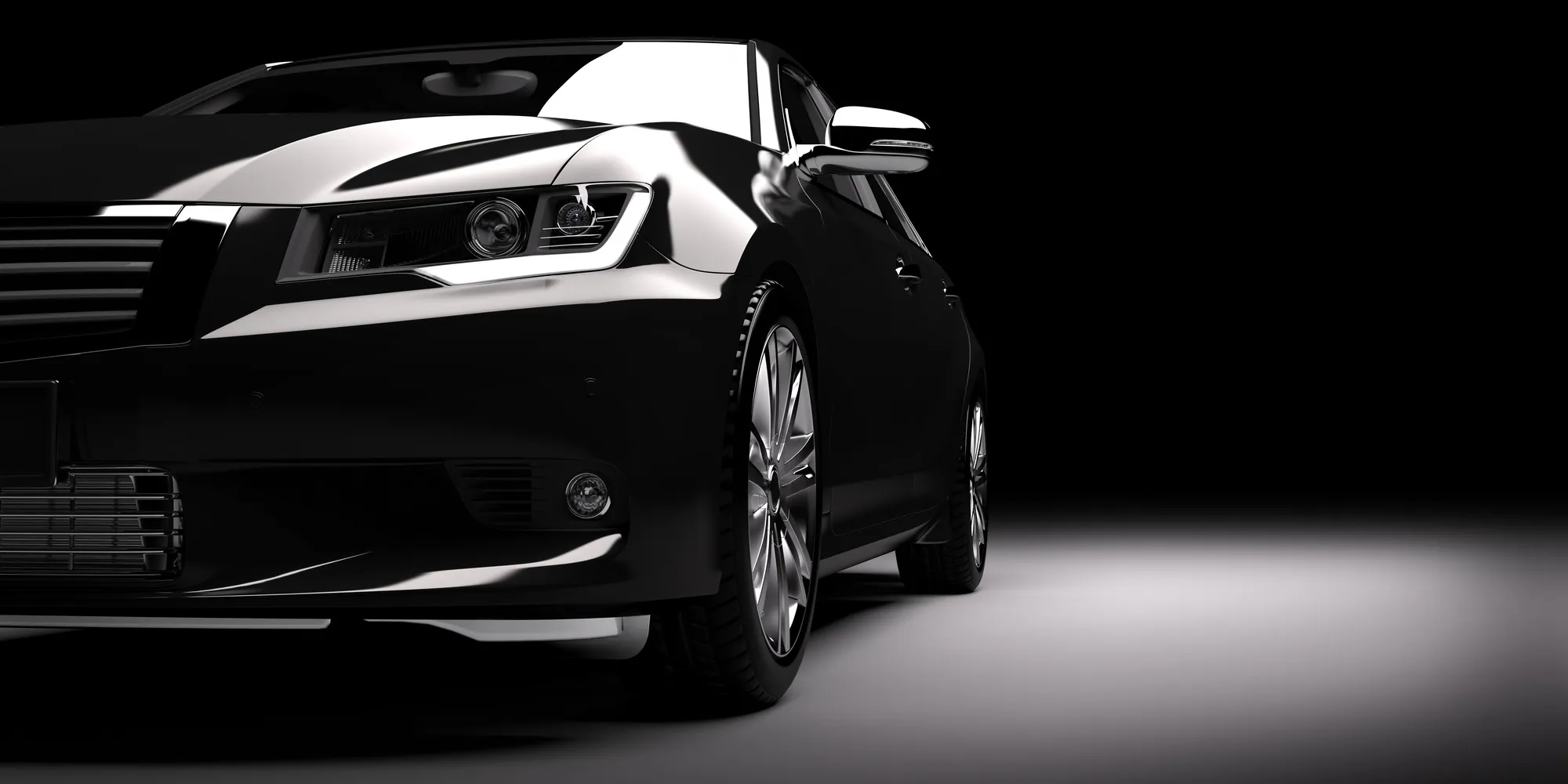 Carrosserie noire d’une voiture mise en valeur par des reflets blancs sur fond sombre.